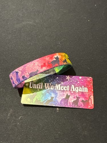 Customer's Until We Meet Again Cat Bracelet with its colorful card, both featuring cat silhouettes on a rainbow background.