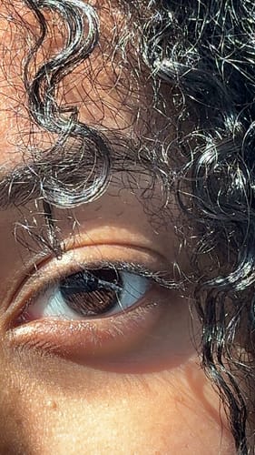 Close-up of a reviewer's dark eye wearing the clear Ivanka Prescription Contact Lens.