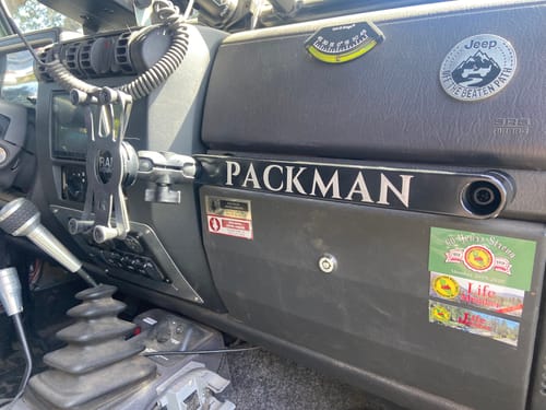 Customer's black Grab Bar Ball installed on a CMM grab bar mounted on the passenger-side dashboard of a vehicle.