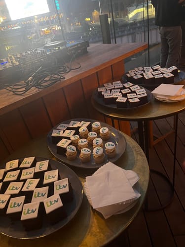 Customer's Corporate Cupcakes with ITV logos displayed on plates at a corporate event.