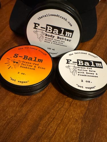 Customer's tin of S-Balm sunblock, displayed with two other F-Balm tins on a wooden surface.