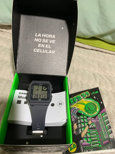 Un cliente muestra su nuevo reloj Casio Vintage dentro de su caja negra y verde original.