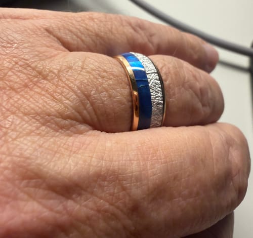 Close-up of a reviewer wearing the Zephyr ring, showing its blue inlay, meteorite texture, and rose gold edges.