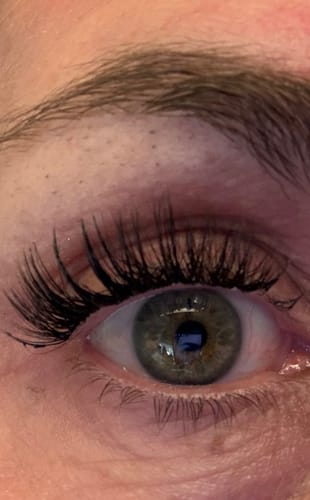 Nahaufnahme eines Auges einer Kundin, das lange, volle Wimpern zeigt, die mit der BOND.MASCARA befestigt wurden.
