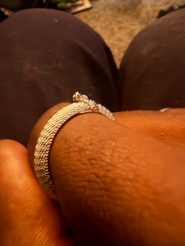 Close-up: A customer wearing the textured silver Ouroboros Ring on their finger.