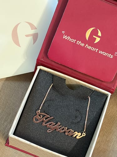 Customer's Rose Gold Personalised Eternal Necklace with a cursive nameplate displayed inside its gift box.