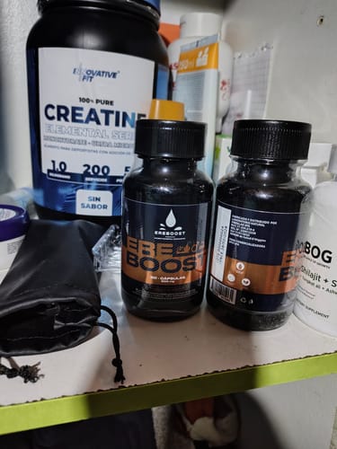 Dos frascos de EREBOOST de un cliente en un estante junto a otros suplementos, incluyendo creatina.