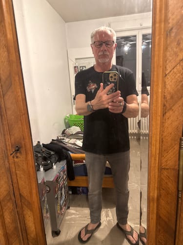 Client portant le T-Shirt Riders noir, qui lui va bien, dans le reflet d'un miroir.