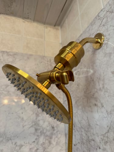 Customer's gold Shower Head Filter installed with a rain shower head in a tiled shower.