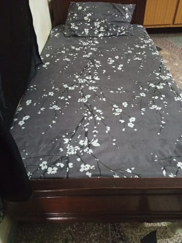 Customer's Cedar Single Bedsheet Set in dark grey with a white floral pattern, neatly made on a bed.