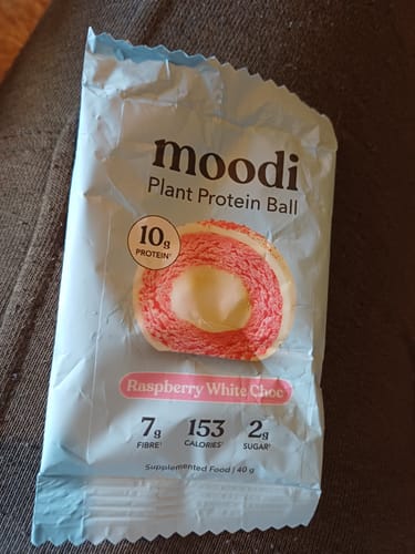 Customer showing the light blue packaging of the Raspberry White Choc Plant Protein Ball.