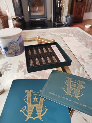 Customer's Discovery Set displayed on a table, showing the open box of fragrance samples and accompanying vouchers.