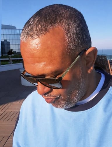 Close-up of a reviewer wearing the soft Volo Crewneck in Della Robbia Blue outdoors.