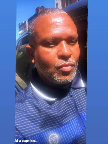 Close-up of a reviewer wearing the blue striped Rete Track Jacket outdoors.