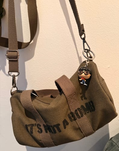 Customer's brown BTS light stick bag with a keychain, showing the 'IT'S NOT A BOMB' text on the side.
