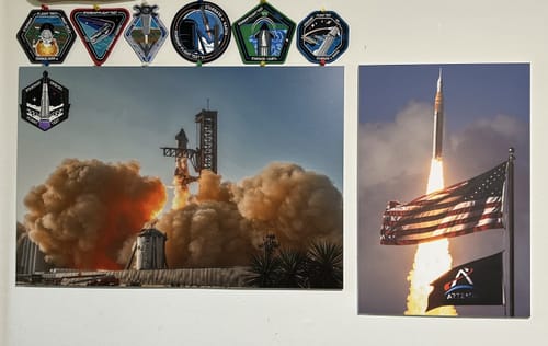 Customer's 'Four Souls, One Rocket' print on a wall next to another space-themed print and several patches.