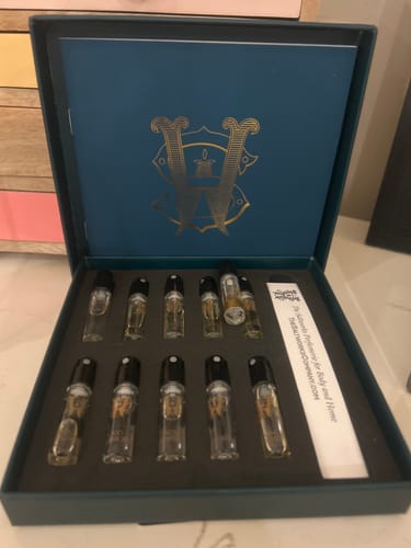 A customer's open Discovery Set with various perfume samples arranged in a teal presentation box.