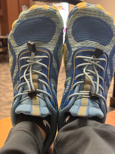 Reviewer's first-person view of their blue patterned Active II - Barefoot Shoes with toggle laces.