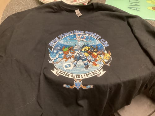 Customer's black long sleeve t-shirt laid flat, showing a large graphic of cartoon characters playing hockey.