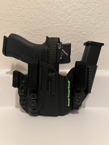 Customer's black AXIS ELITE holster holding a pistol and magazine, showing a custom light green shock cord.