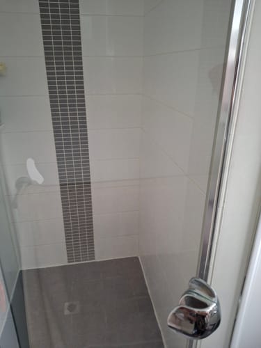 Reviewer's sparkling clean shower stall after using the KoalaCloth.