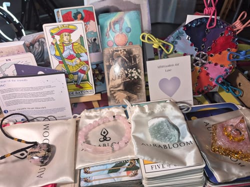 Reviewer's collection of items from the AuraBloom Subscription Box, including jewelry, crystals, and affirmation cards.