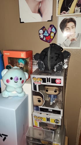 Customer's black ARMY BOMB PLUSH KEYRING displayed on a shelf with other merchandise.