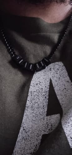 Close-up of a customer wearing the black Legacy necklace with several personalized beads.