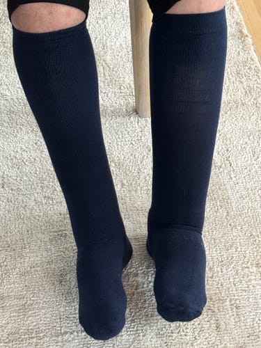 Reviewer wearing dark blue, knee-high Performance Eucalyptus Compression Socks.