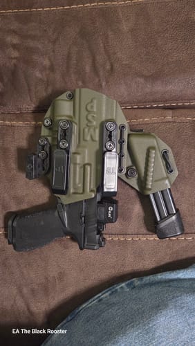Customer's green MSP PRO SERIES FLX holster with a pistol inside and an attached magazine carrier, resting on a couch.