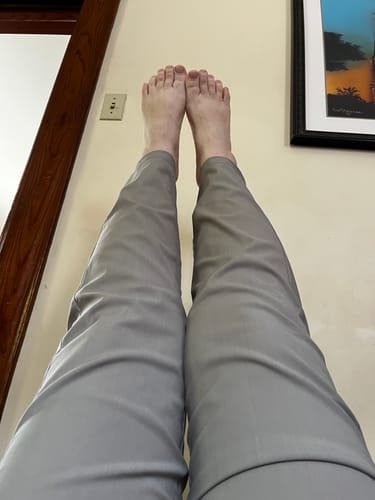 Reviewer showing how the Nicole Ankle Pants stay in place with their legs raised, demonstrating the fit and flexibility.