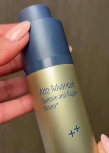 Customer holding the gold and blue bottle of SkinBetter Science Alto Advanced Defense and Repair Serum.