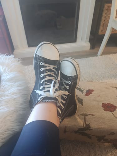 Reviewer relaxing with their feet up, wearing the black canvas Roam I - Barefoot Shoes indoors.