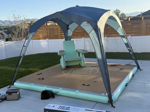 Reviewer's Pop 'N Go® Canopy set up on a large inflatable float in a backyard.