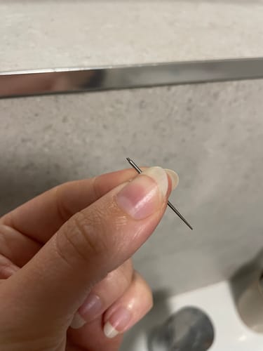 Customer holding the slender, needle-like Flatback Insertion Taper between their fingers.