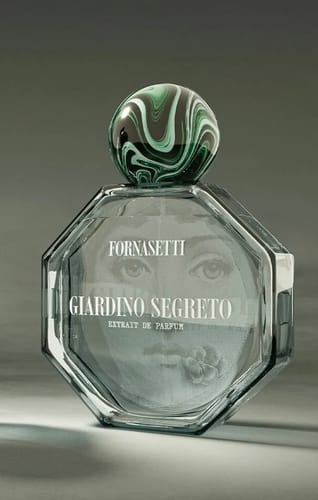 Il recensore mostra il flacone ottagonale di Giardino Segreto Extrait Fornasetti con il suo tappo marmorizzato.