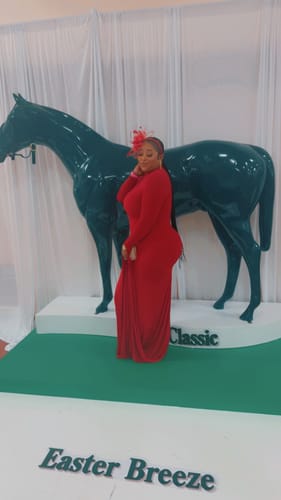 Reviewer posing in the long, red Naked Draped Sleeve Maxi Dress at an event.
