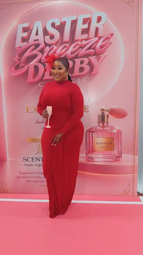 Reviewer smiling in the form-fitting, red Naked Draped Sleeve Maxi Dress at an event.