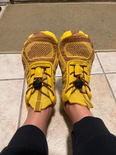 Reviewer's feet in fun, yellow Active II Pro - Barefoot Shoes, seen from a top-down perspective.