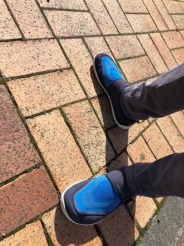Customer wearing the blue and black slip-on Flex Ⅰ - Barefoot Shoes on a brick path.