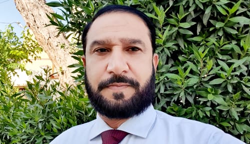 A reviewer in a collared shirt, pictured outdoors, who reviewed the Summer Box fragrance.
