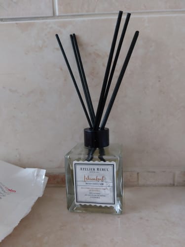 Recensent toont de Istanbul geurstokjes in een vierkante fles met zwarte stokjes.
