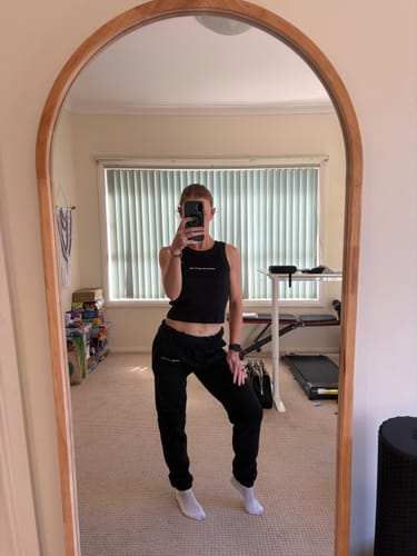 Reviewer showing the fit of the black Legacy Sweat Pants in a mirror selfie.