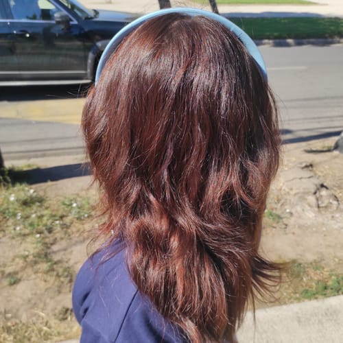 Clienta mostrando su pelo de color cobrizo intenso tras usar la Henna Jamila BAQ.