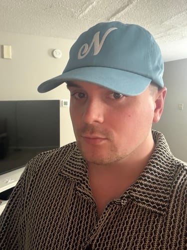 Customer wearing a light blue hat with white Custom Embroidery of a letter 'N'.