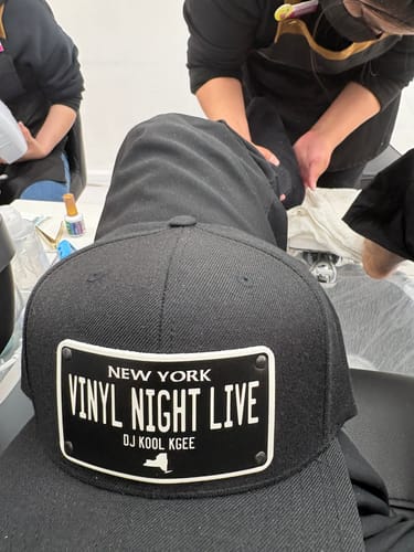 Customer's black New York Blackout Plate Hat with a custom patch reading "VINYL NIGHT LIVE" and "DJ KOOL KGEE".