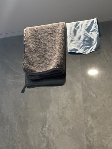 Customer's grey KoalaCloth hanging in a bathroom next to the blue cloth it replaced.