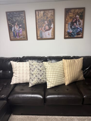 Customer's four patterned House Becomes Home pillow covers lined up on a dark leather sofa.
