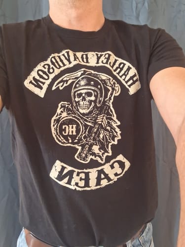 Un client porte le T-shirt noir Faucheuse HC, montrant de près l'impression de la faucheuse sur le torse.