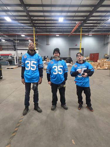 Three customers standing together in matching blue Panther football jerseys with the number 35.